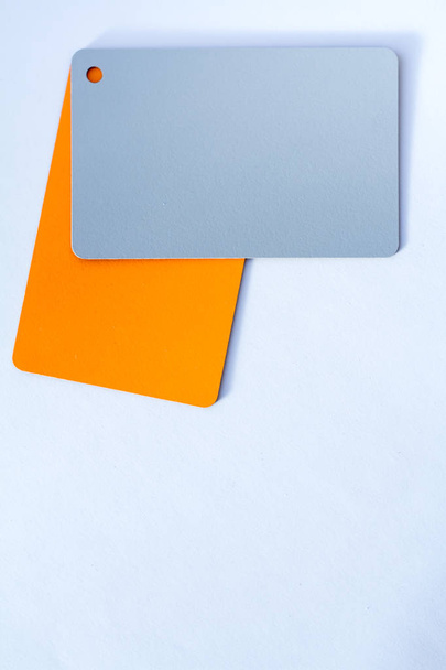 Έννοια των έγχρωμων καρτών σε λευκό φόντο δύο χρώματα γκρι και πορτοκαλί απομόνωμα σε λευκό φόντο - Φωτογραφία, εικόνα