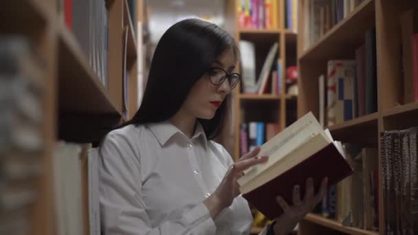 4K Confident Millennial Woman Student Holding Books In Quiet Library Setting - Metraje, vídeo