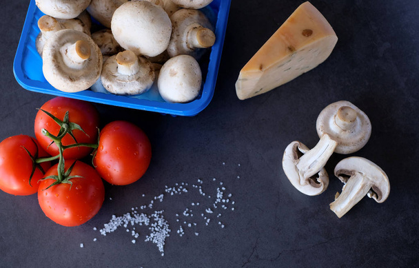 Food ingredients for pizza on black background, as tomatoes, cheeze or mushrooms - Photo, image