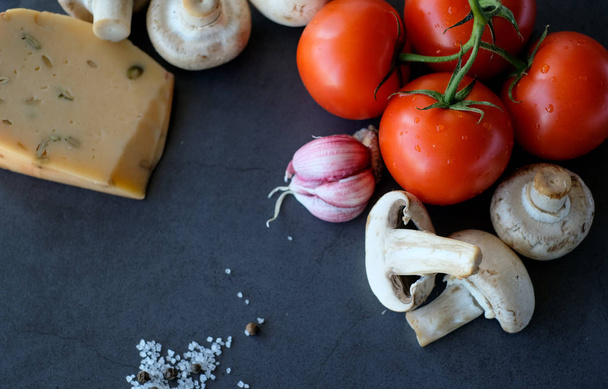 Food ingredients for pizza on black background, as tomatoes, cheeze or mushrooms - Foto, Imagem