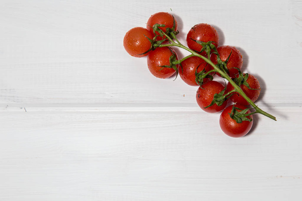 The photo shows a branch of juicy, red, tomato on a white background. - Foto, Imagem