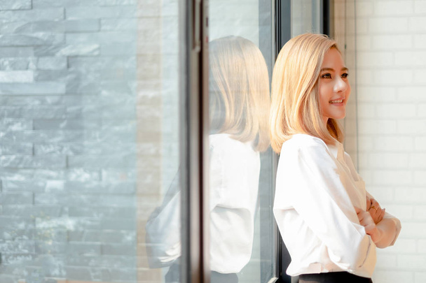 Young businesswoman standing with arms crossed near the office w - Foto, Bild