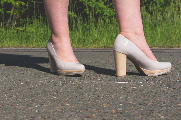 Pernas de uma mulher usando sapatos elegantes de salto alto
 - Foto, Imagem