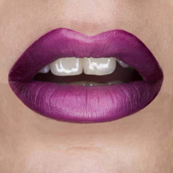 Close-up macro hermosos labios con lápiz labial violeta mate púrpura. Gradiente púrpura, dientes blancos y boca abierta. Arte labial
 - Foto, Imagen