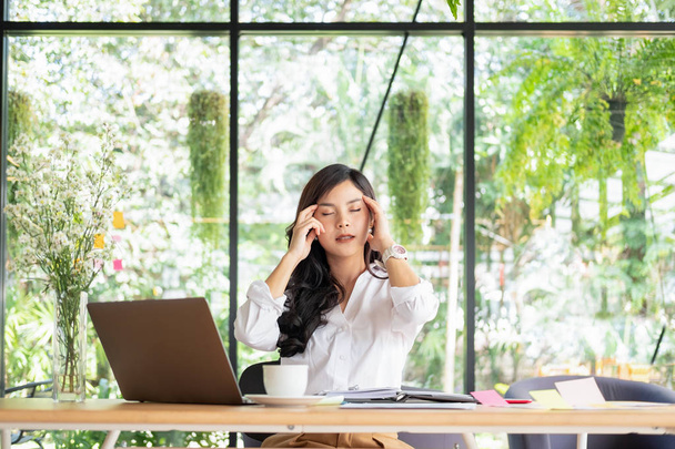 νεαρή επιχείρηση γυναίκα κάθεται στο τραπέζι στο γραφείο νιώθοντας κούραση - Φωτογραφία, εικόνα