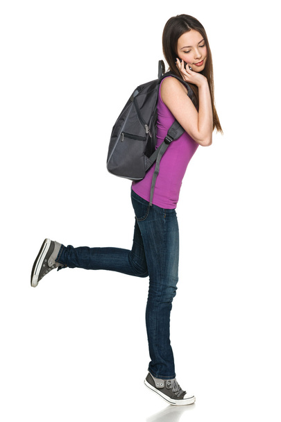 Young female with backpack talking on cell phone - Fotoğraf, Görsel