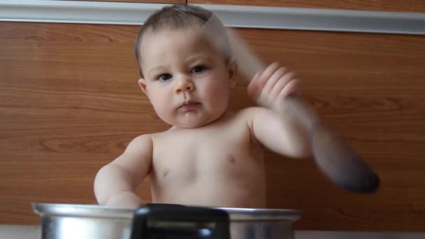 かわいい6ヶ月の男の赤ちゃんは、調理鍋と木製のスプーンで遊んで - 映像、動画
