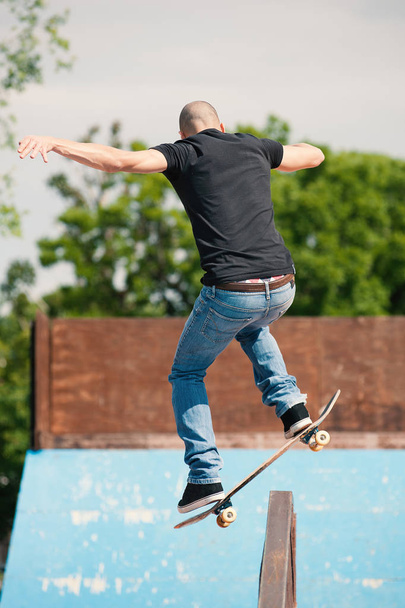 Skateboarder doing a skateboard trick at skate park. - Fotó, kép