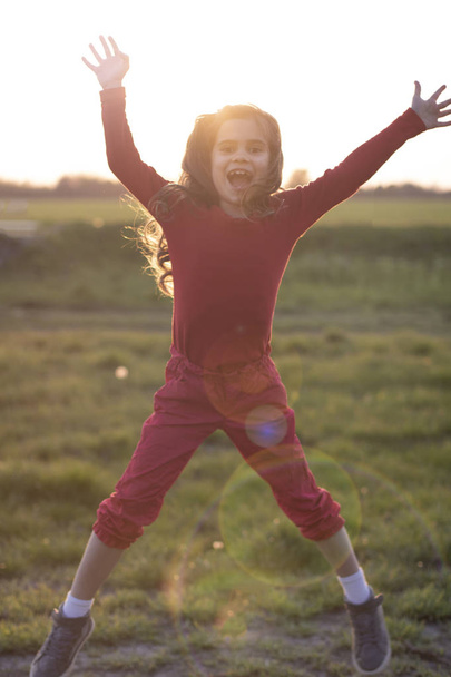 legrační dívka skákající na pozadí slunce - Fotografie, Obrázek