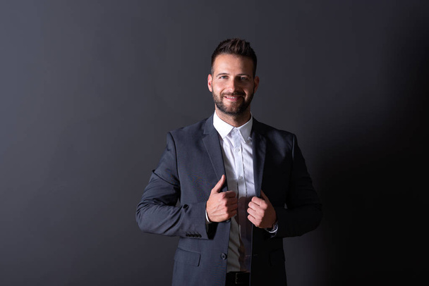 Un homme d'affaires souriant debout dans un studio - Photo, image