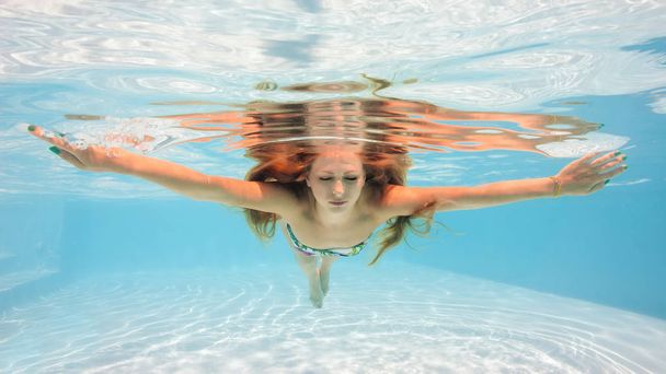 スイミングプールでビキニを着た水中女性の肖像画.  - 写真・画像