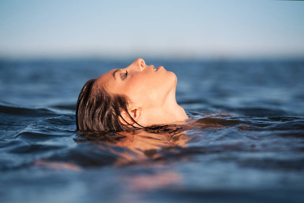 Sensual woman posing inside the water at the sea.  - Photo, image