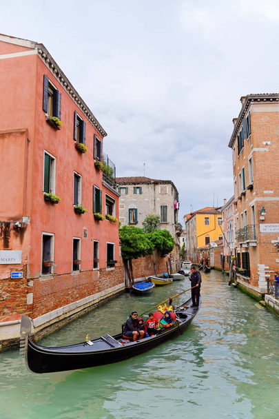 Gondola na kanale przepływającym między zabytkowymi budynkami w Wenecji, 4 maja 2018 Włochy - Zdjęcie, obraz