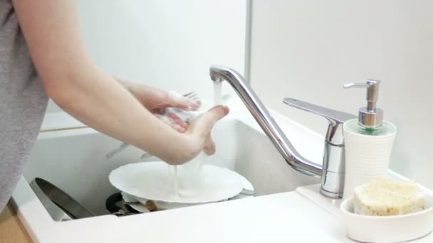 Ženské ruce opláchněte plastovou lžičku, nůž a vidličku na kuchyni. Mytí nádobí rutina. - Záběry, video