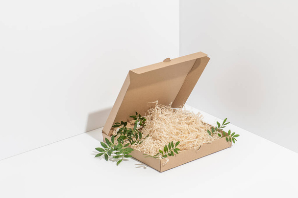 Disposable, recyclable paper pizza box in the corner over white background - Foto, immagini