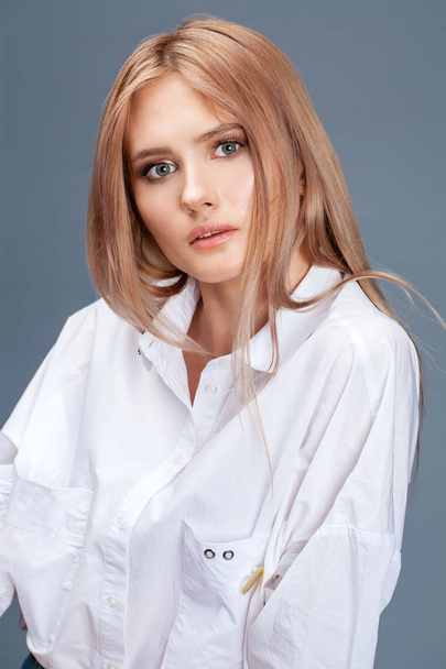 Closeup portrait of a young beautiful blonde woman in a white sh - Foto, Imagem