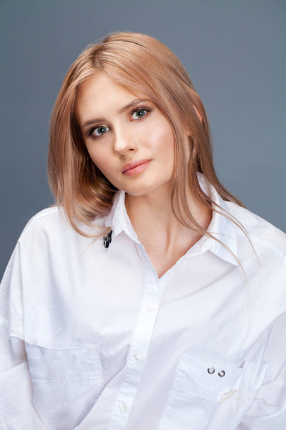 Closeup portrait of a young beautiful blonde woman in a white sh - Foto, imagen