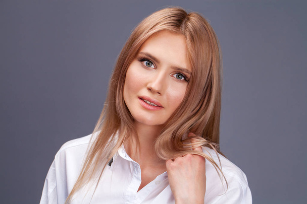 Closeup portrait of a young beautiful blonde woman in a white sh - Foto, afbeelding