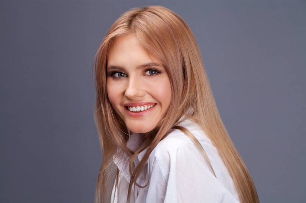 Closeup portrait of a young beautiful blonde woman in a white sh - Фото, зображення