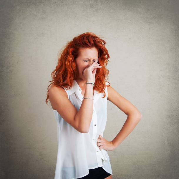 Yawning redhead woman portrait against grunge background.  - 写真・画像