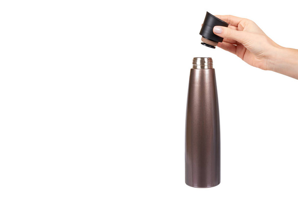 Hand with brown metal thermos, travel mug for hot drinks. - Foto, afbeelding