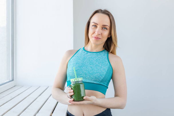 Здоровая, диета, детоксикация и потеря веса - молодая женщина в спортивной одежде с зеленым смузи
 - Фото, изображение