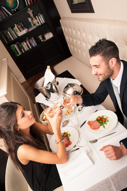 Attractive elegant young couple having dinner at the restaurant. - Фото, изображение