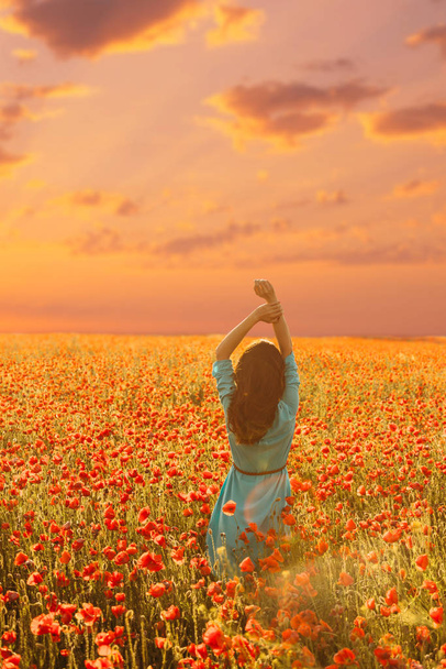 Ρομαντική γυναίκα περπάτημα στο χωράφι λουλουδιών παπαρούνας.  - Φωτογραφία, εικόνα