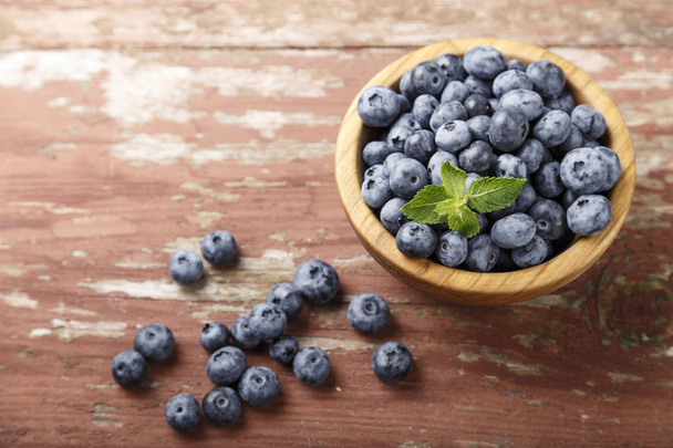 blueberries in a brown wooden plate - Фото, изображение
