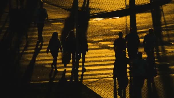 Emberek sziluettje tömeg forgalom a közúti átkelés hosszú árnyékok naplemente valós időben - Felvétel, videó
