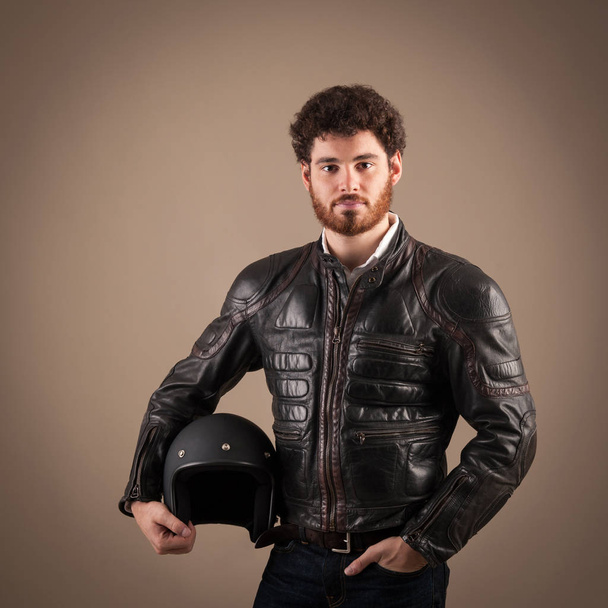 Confident young man portrait with leather jacket and helmet agai - Photo, image