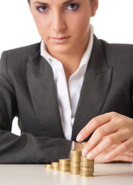 Businesswoman hand with stacks coins against white background. - Φωτογραφία, εικόνα