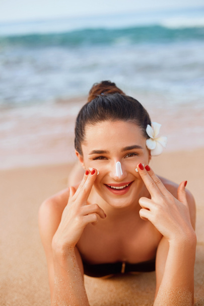 Portret van mooie jonge vrouw met schone frisse huid aanraken gezicht. Suntan lotion. Bescherming tegen de zon. Zonnebrandcrème. Huid-en lichaamsverzorging. gezichtsbehandeling. Cosmetologie, schoonheid - Foto, afbeelding