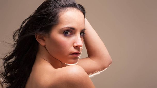 Young intimate brunette woman beauty portrait against brown background.  - Foto, Imagem