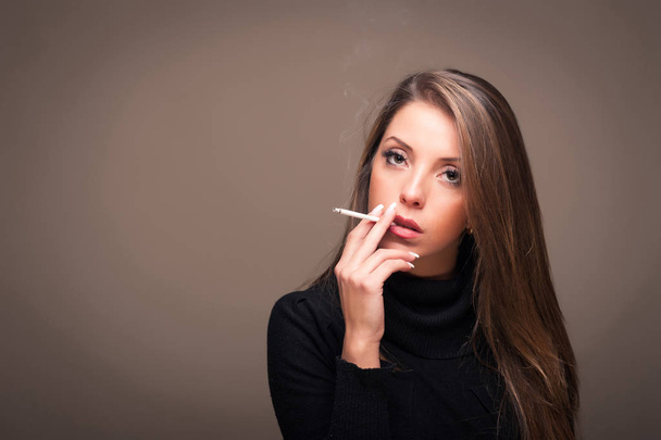 Portrait of woman smoking cigarette. Studio fashion photo on dark background. - Fotoğraf, Görsel