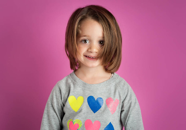 Young smiling girl portrait against pink background. - Foto, Imagem