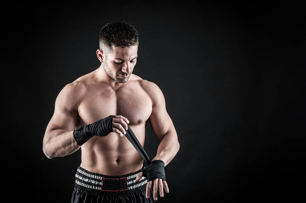 Sportsman kick boxer intense portrait against black background.  - 写真・画像