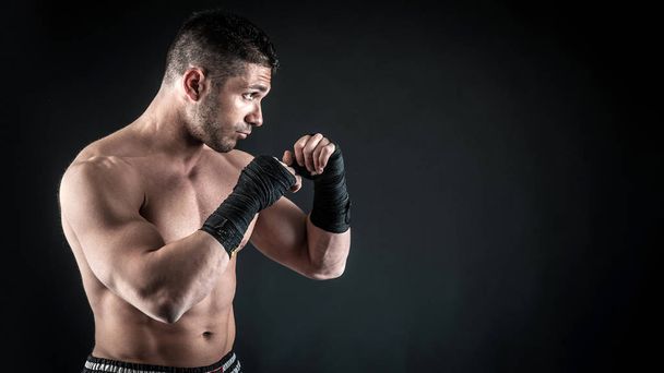 Sportsman kick boxer portrait against black background.  - Foto, Imagem