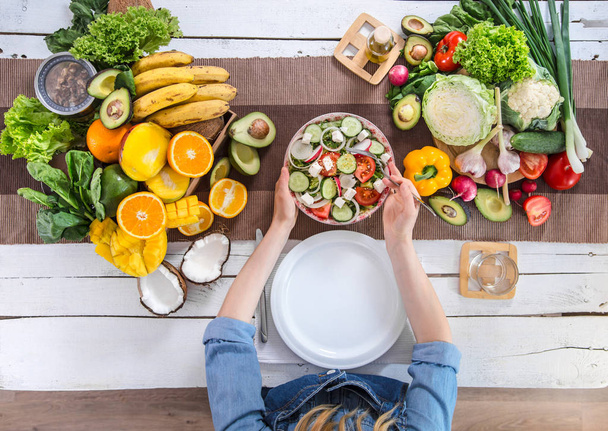 A mulher na mesa de jantar com comida orgânica, a vista de
  - Foto, Imagem