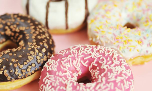 Smakelijke donuts op roze achtergrond. Nationale donuts dag. - Foto, afbeelding