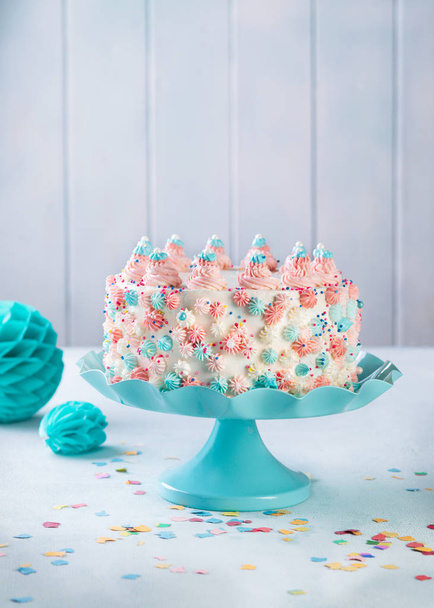Gâteau d'anniversaire à la crème beurre vanille avec des saupoudres colorées sur un fond neutre
. - Photo, image