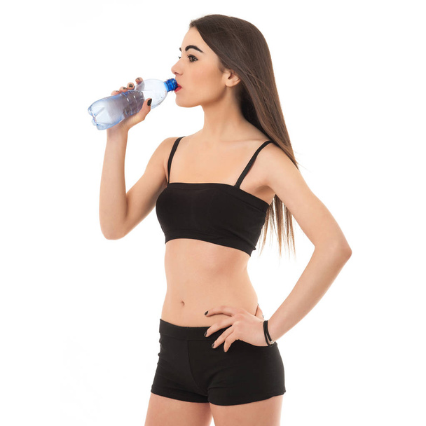 Sporty young woman drinking water, isolated against white background. - Photo, Image