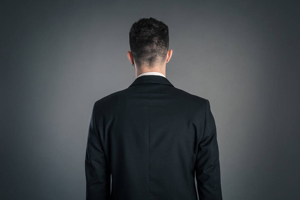 Portrait of a businessman back view isolated on dark background. Studio shot.  - Fotoğraf, Görsel