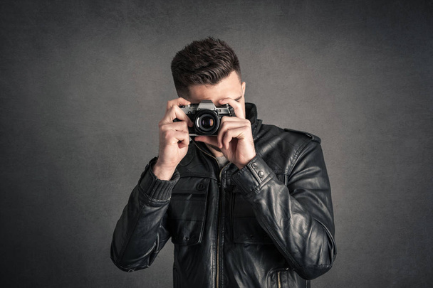 Man with camera portrait over dark grunge background.  - Fotó, kép