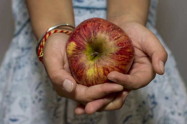 ein Apfel in der Hand und in beiden Händen gehalten - Foto, Bild