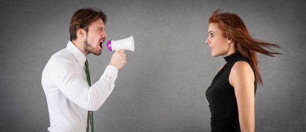 Man shouting to woman with megaphone against grunge background.  - Foto, Imagen