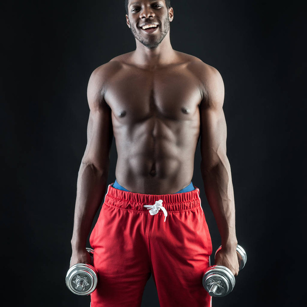 Happy young man shirtless portrait training with dumb-bell again - Foto, imagen