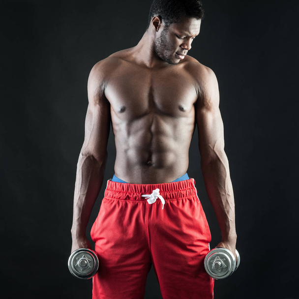Powerful young man shirtless portrait training with dumb-bell ag - Photo, Image