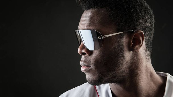 Confident black man close up portrait with sunglasses against da - Фото, зображення