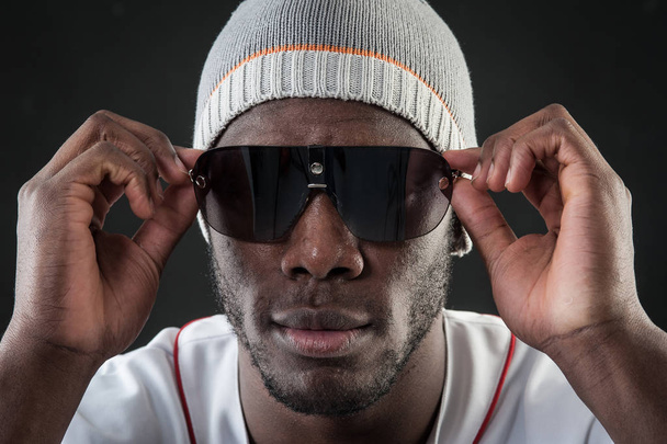 Confident black man close up portrait with sunglasses against bl - Foto, Imagen